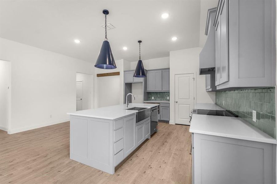 Kitchen featuring backsplash, light light floors gray cabinetry, light stone countertops, and recessed lighting