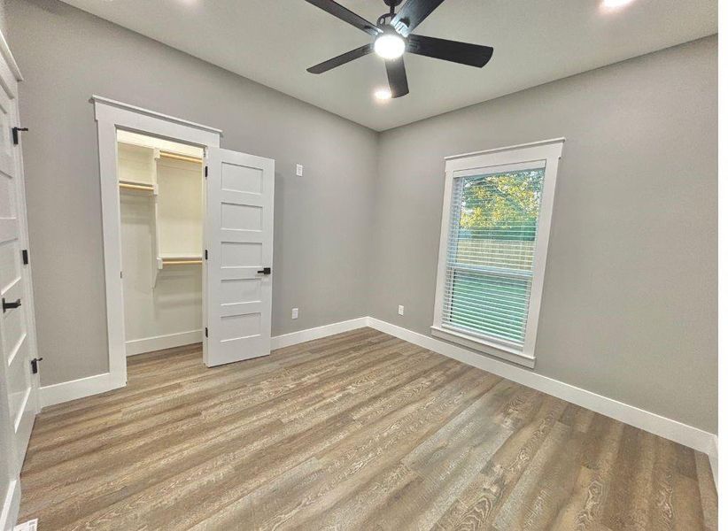 Unfurnished bedroom featuring wood finished floors, a spacious closet, recessed lighting, and ceiling fan Unfurnished bedroom featuring wood finished floors, a spacious closet, recessed lighting, and ceiling fan