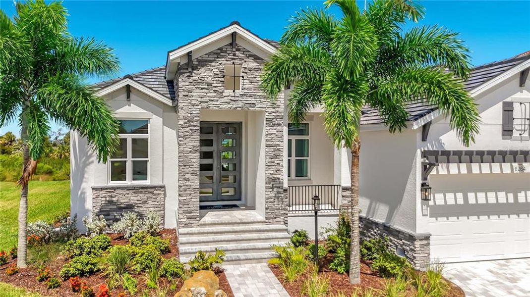 Front exterior of a new home in Legends Bay, Bradenton, FL, highlighting curb appeal (Image 21). Front exterior of a new home in Legends Bay, Bradenton, FL, highlighting curb appeal (Image 21).