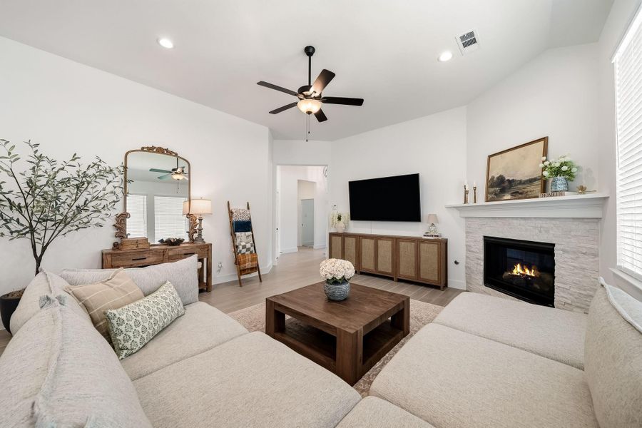 The family room makes an impressive statement with rich hardwood tile flooring, soaring ceilings and recessed lighting that enhances the room’s bright, open atmosphere.