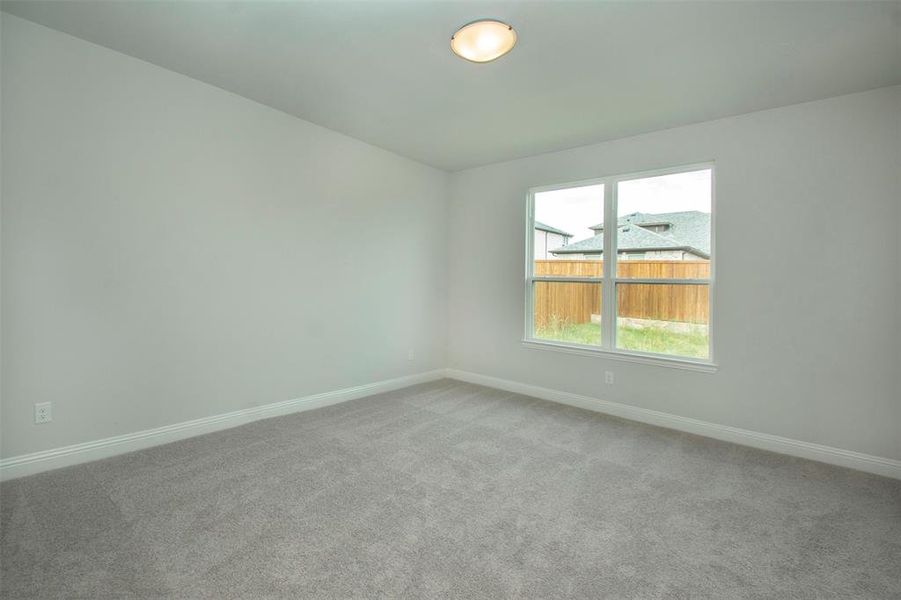 Spare room featuring baseboards and carpet flooring Spare room featuring baseboards and carpet flooring