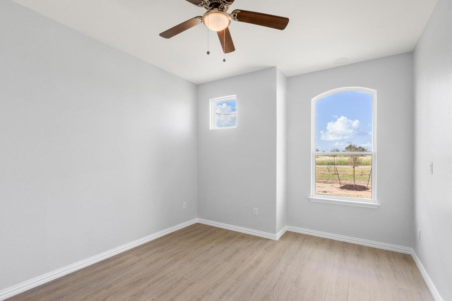 Unfurnished room with light wood finished floors and a ceiling fan Unfurnished room with light wood finished floors and a ceiling fan