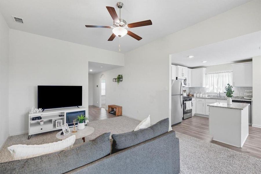 Living area featuring a ceiling fan, arched walkways, light wood-type flooring, and recessed lighting