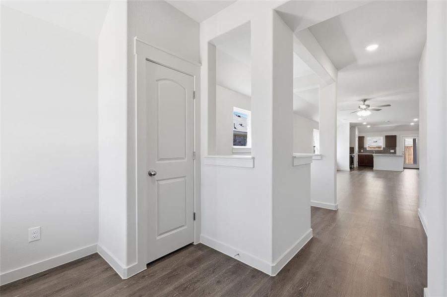 Hallway with plenty of natural light, dark wood-style flooring, and recessed lighting