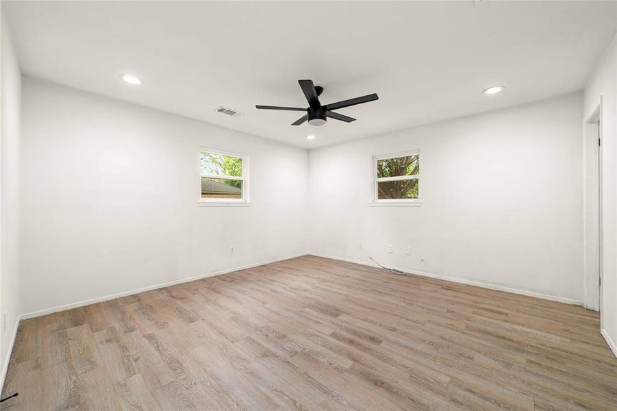 Unfurnished room with light wood-type flooring, plenty of natural light, visible vents, and recessed lighting Unfurnished room with light wood-type flooring, plenty of natural light, visible vents, and recessed lighting