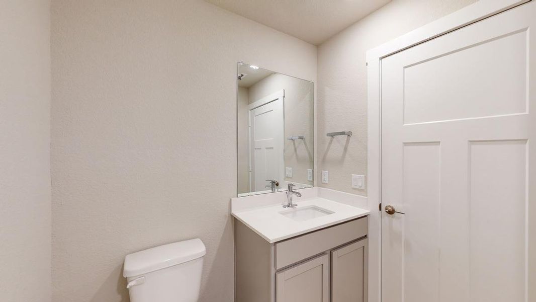 Half bathroom with vanity and toilet