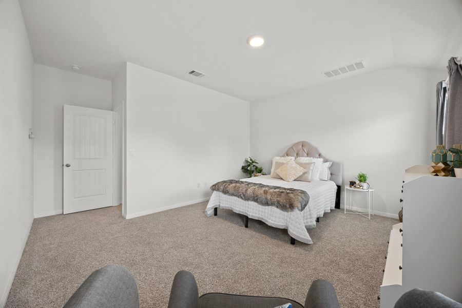 Bedroom featuring light carpet, vaulted ceiling, and recessed lighting