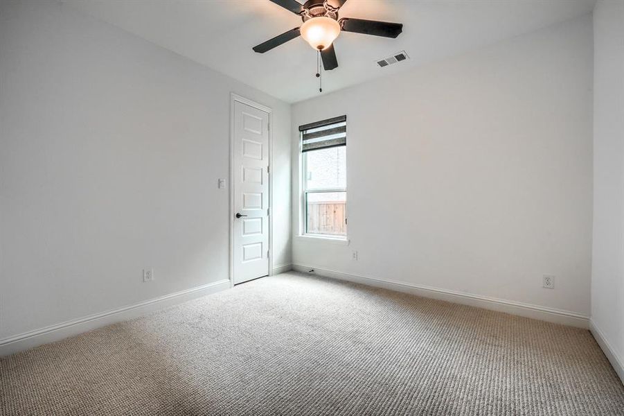 Unfurnished room with visible vents, a ceiling fan, baseboards, and carpet floors