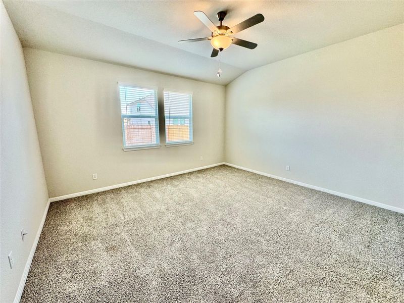 Spare room with carpet, vaulted ceiling, and ceiling fan Spare room with carpet, vaulted ceiling, and ceiling fan