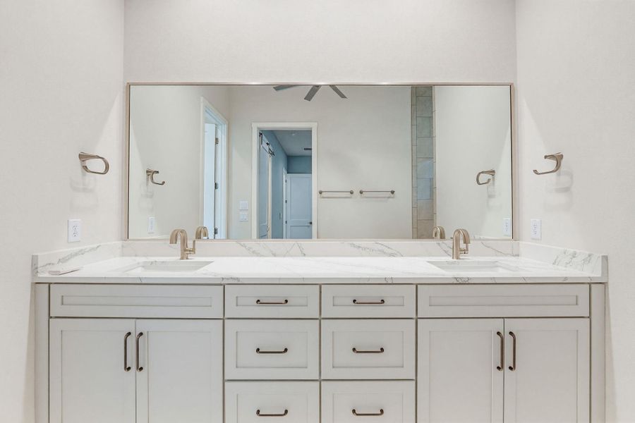 A refined bathroom featuring a generously sized dual vanity with sleek fixtures.