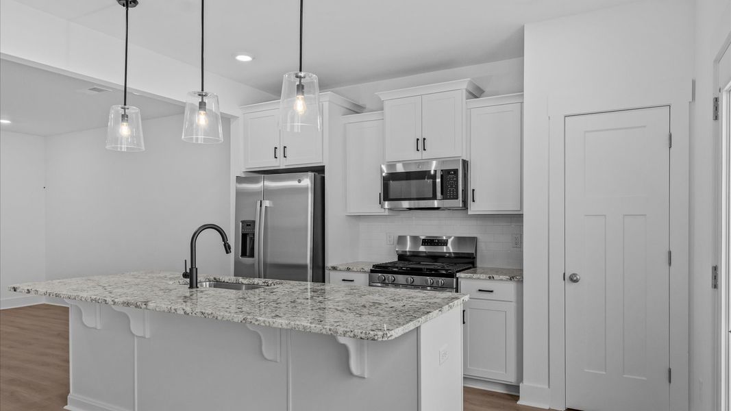 Highly skilled craftsmanship shines in this modern kitchen with pendant lighting and a central island focal point Highly skilled craftsmanship shines in this modern kitchen with pendant lighting and a central island focal point