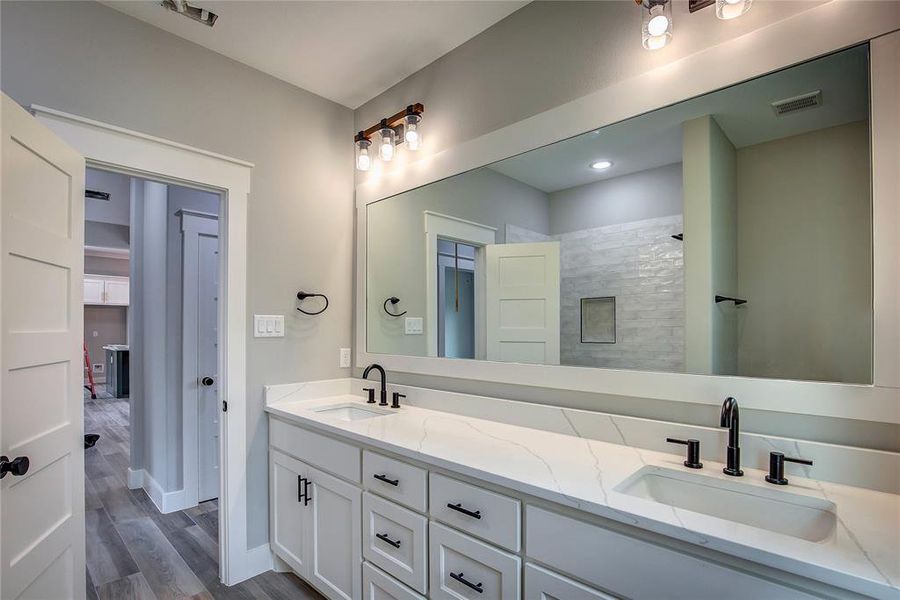 Bathroom with dual vanity and hardwood / wood-style flooring Bathroom with dual vanity and hardwood / wood-style flooring