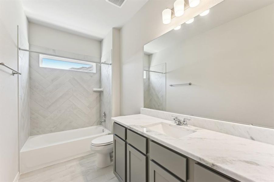 The combination tub and shower offers both convenience and relaxation, while the modern tile work adds a touch of visual interest.