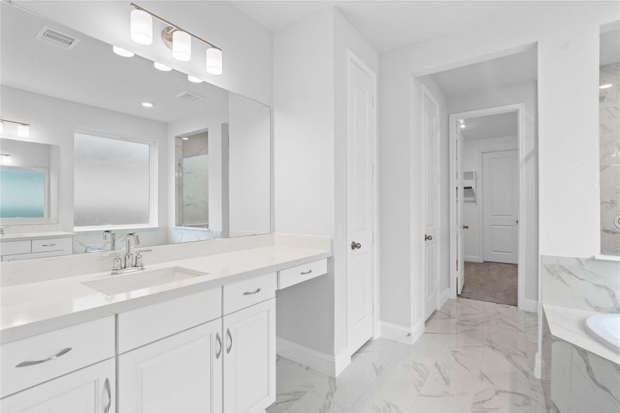 Modern primary bath features dual vanities with sleek cabinetry, quartz countertop, and crisp chrome fixtures for a truly contemporary feel.