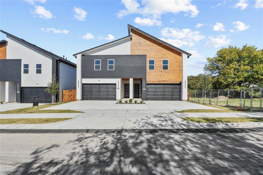 View of front of house with a gate, a garage, and driveway