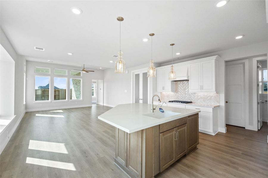 Enjoy an open, airy living experience with a commanding view from the heart of the home. This gourmet kitchen seamlessly flows into the main living area, where oversized windows flood the entire space with abundant natural light and frame a picturesque view of the serene backyard.