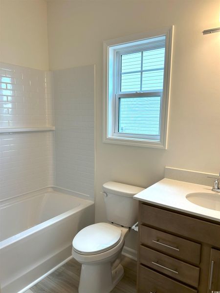 Full bath with plenty of natural light, vanity, and bathtub / shower combination