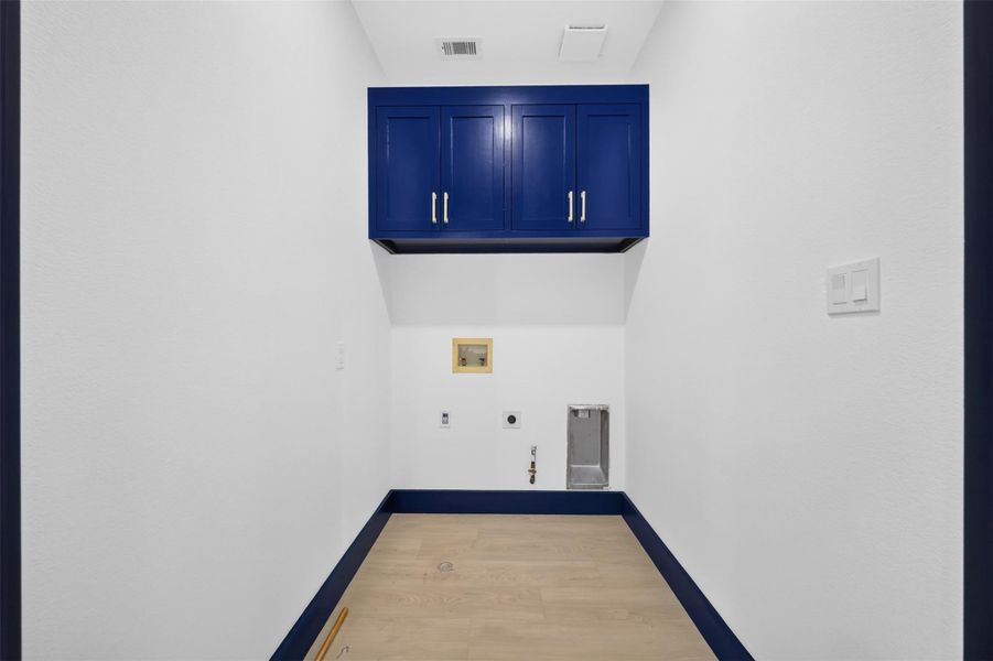 Dedicated laundry area with built in cabinetry for convenient storage