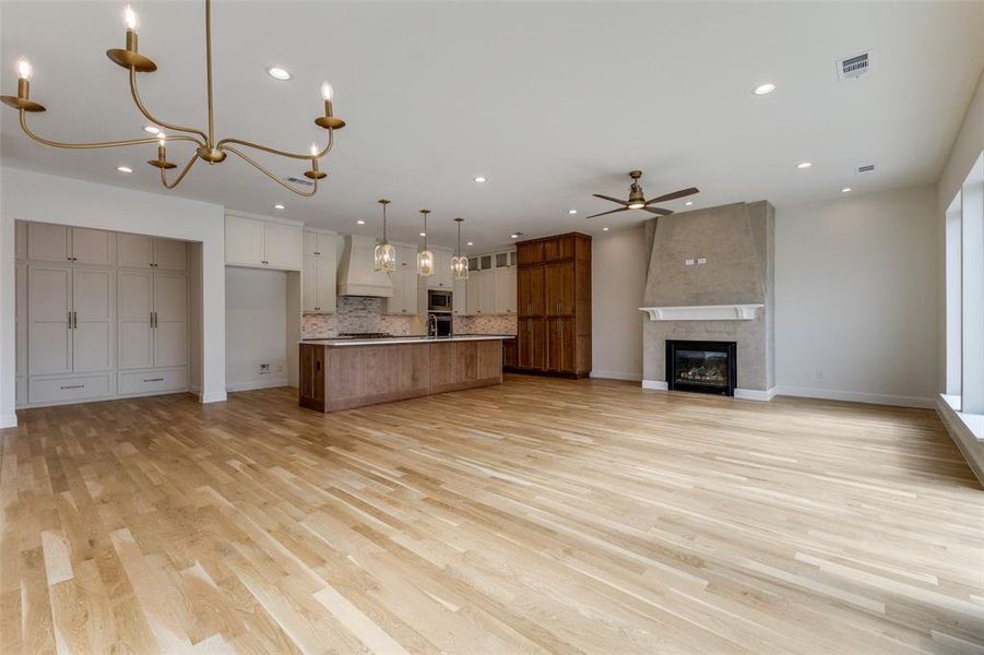 Kitchen featuring custom range hood, open floor plan, a ceiling fan, recessed lighting, and tasteful backsplash