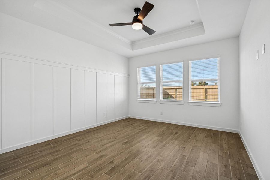 Spacious primary suite with decorative feature wall