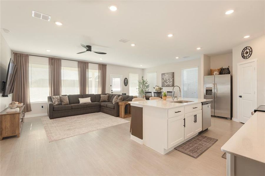 Open-concept living space featuring wood-finish flooring, recessed lighting, and a ceiling fan Open-concept living space featuring wood-finish flooring, recessed lighting, and a ceiling fan