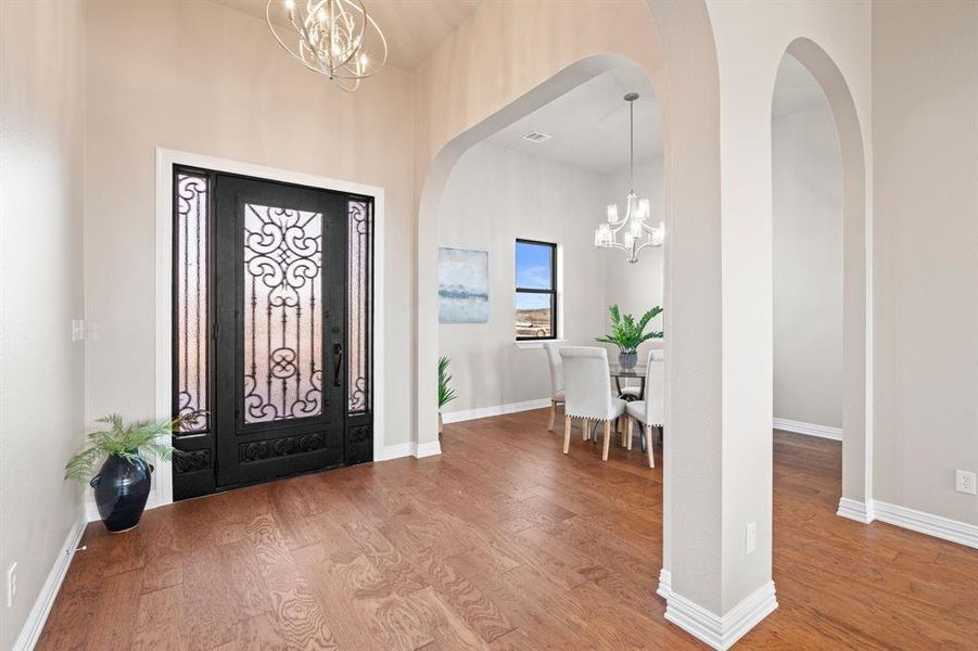 Foyer entrance featuring an inviting chandelier and hardwood / wood-style flooring