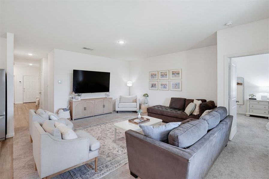 Open-concept living area featuring light-toned walls and recessed lighting