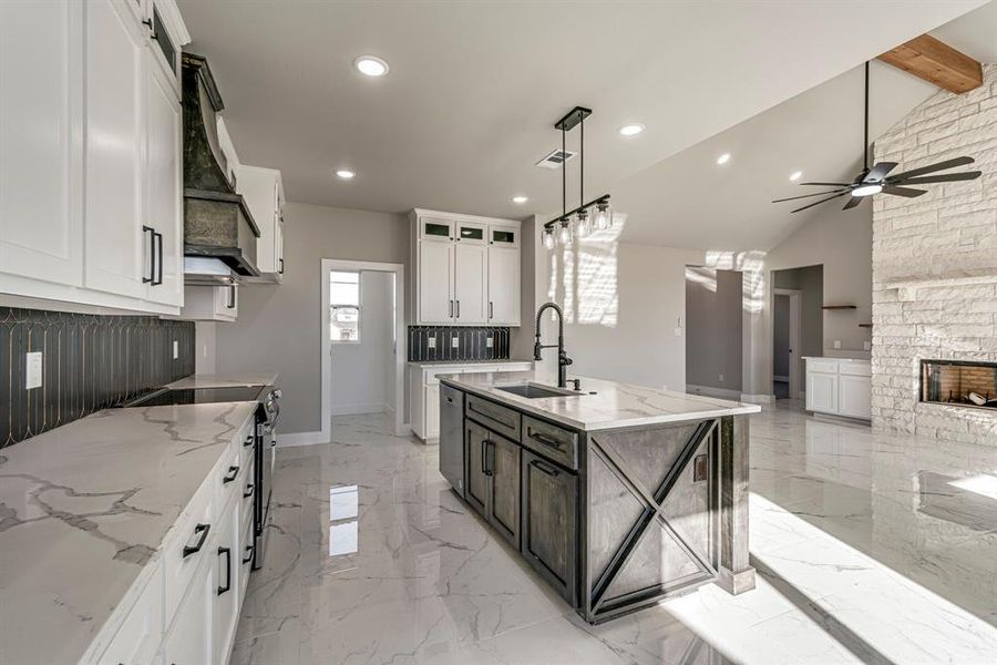 Kitchen featuring stainless steel electric range oven, premium range hood, ceiling fan, a sink, and marble finish floor