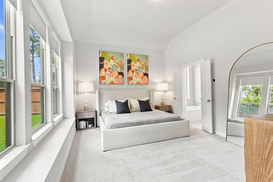 Expansive primary bedroom with three large windows and window seat. Automatic window shades on windows