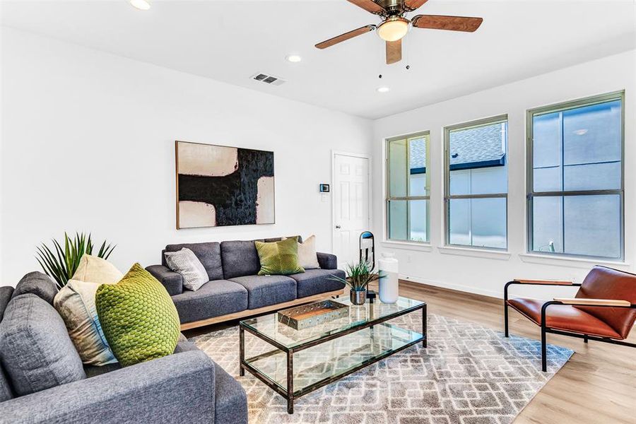 Living room with ceiling fan and hardwood / wood-style floors