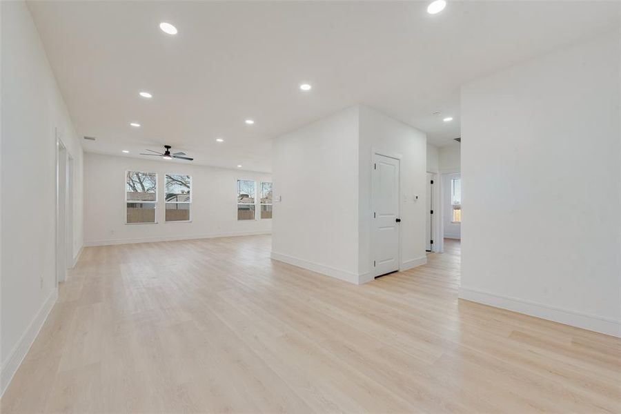 Empty room with ceiling fan and light hardwood / wood-style floors