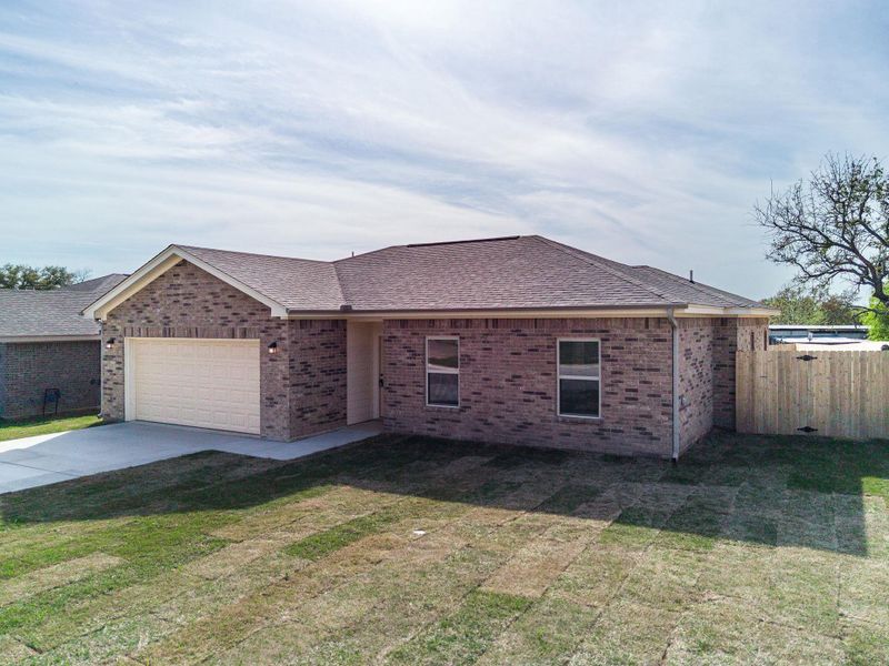 Ranch-style home with concrete driveway, roof with shingles, a front lawn, an attached garage, and fence Ranch-style home with concrete driveway, roof with shingles, a front lawn, an attached garage, and fence