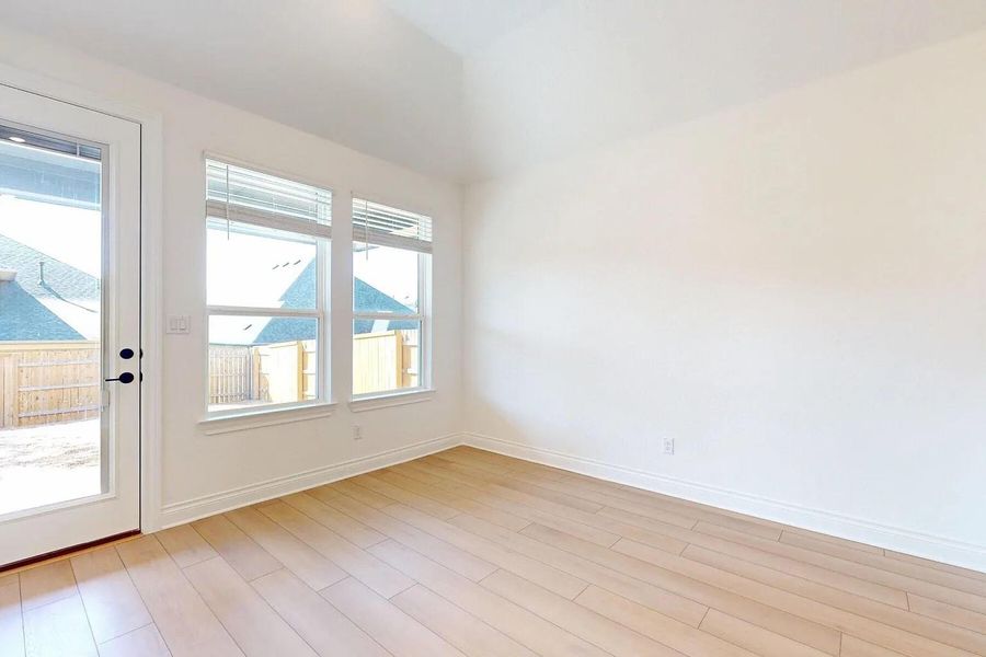 This bright room features light-toned hardwood flooring, white walls, and a white trim