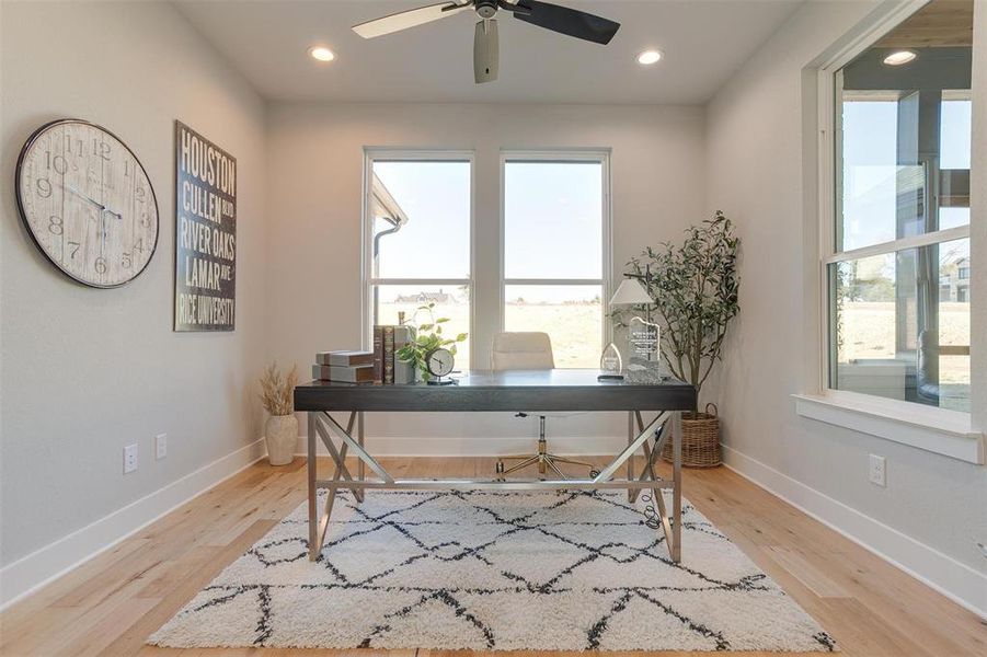 Office space with light wood-type flooring and ceiling fan