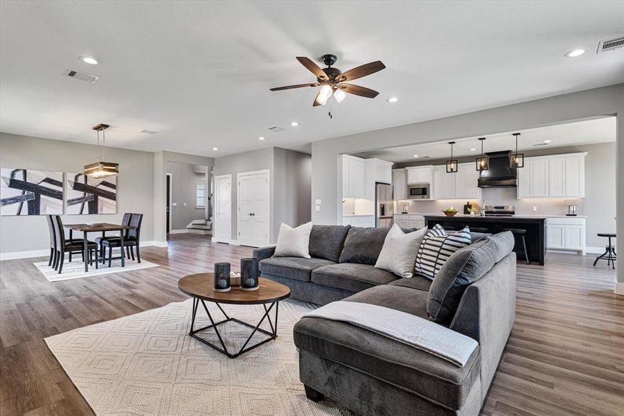 Living room featuring ceiling fan and light hardwood / wood-style flooring