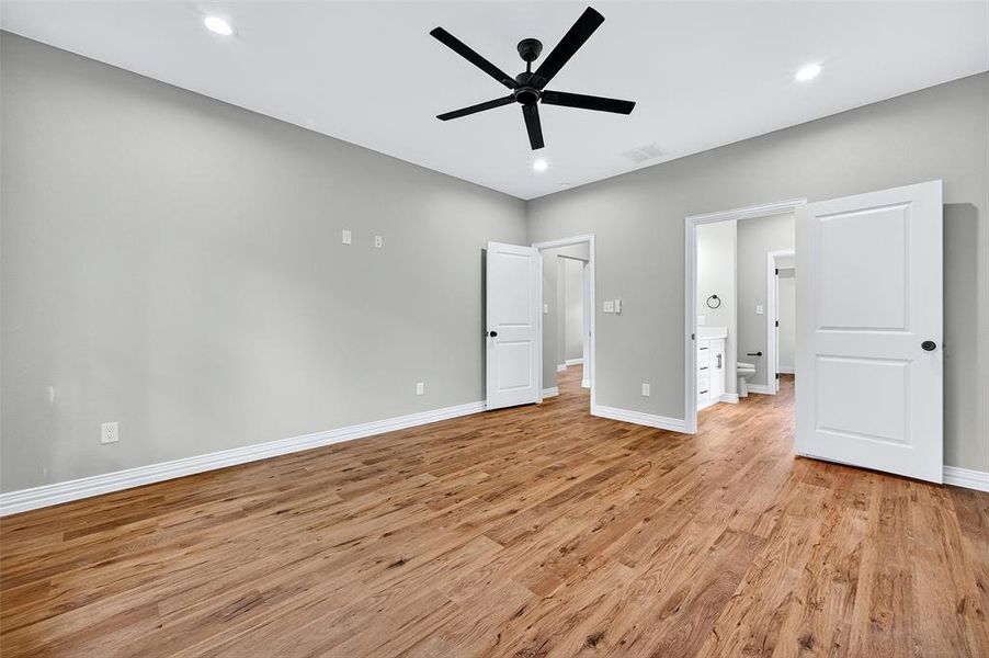 Unfurnished bedroom with light wood-style flooring, recessed lighting, a ceiling fan, and ensuite bath Unfurnished bedroom with light wood-style flooring, recessed lighting, a ceiling fan, and ensuite bath