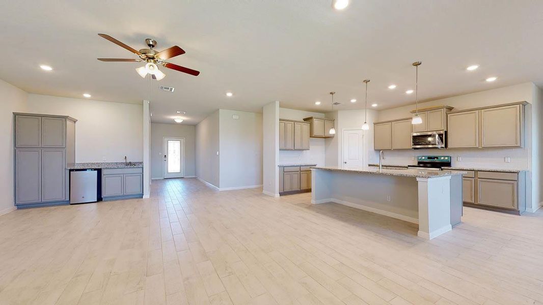 Kitchen featuring gray cabinetry, an island with sink, decorative light fixtures, recessed lighting, and stainless steel appliances
