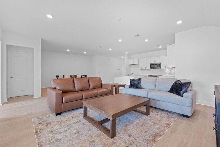 Living room with light wood-style flooring and recessed lighting Living room with light wood-style flooring and recessed lighting