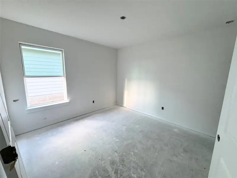 Unfurnished room featuring unfinished concrete floors