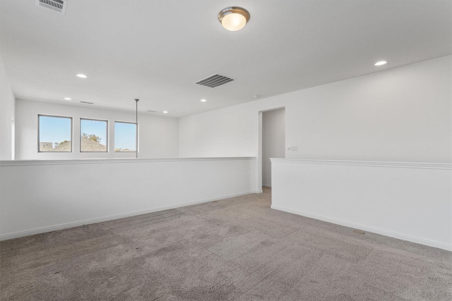 Carpeted spare room with baseboards and recessed lighting