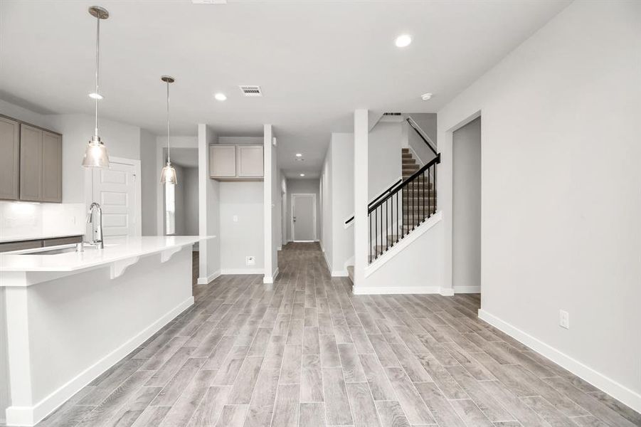 Discover another perspective of this stunning kitchen, generously appointed with an abundance of counter space. Sample photo of completed home with similar floor plan. As-built interior colors and selections may vary.