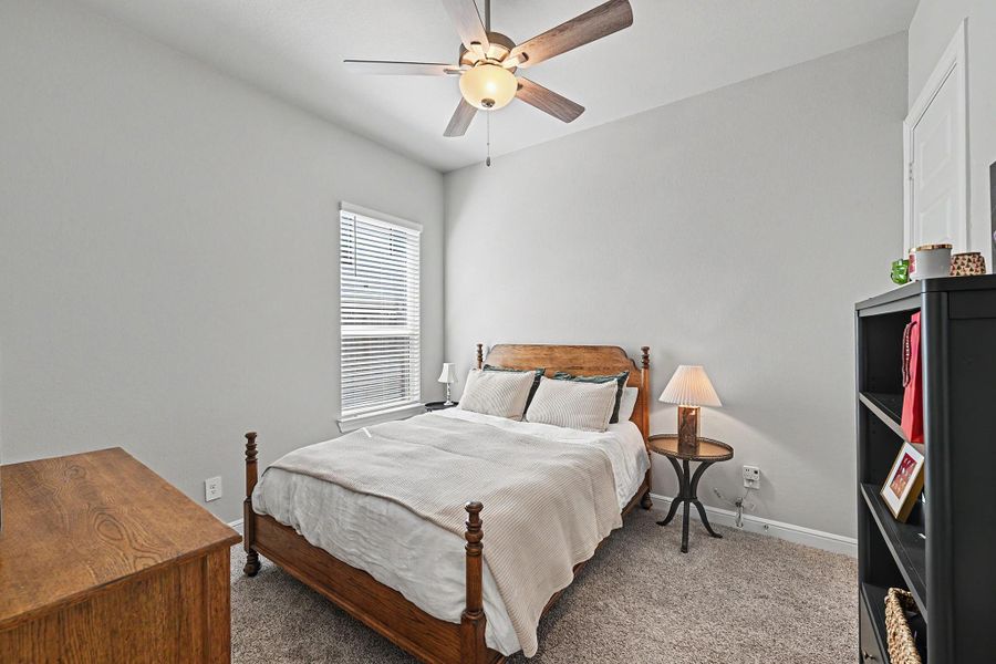 The first-floor second bedroom offers a comfortable retreat with high ceilings and soft carpet flooring. The first-floor second bedroom offers a comfortable retreat with high ceilings and soft carpet flooring.