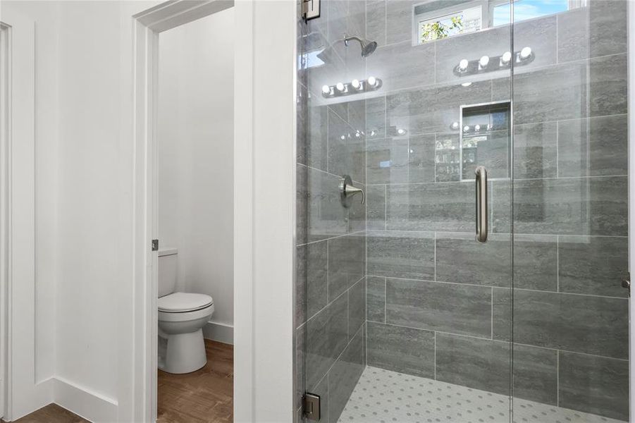 Bathroom with walk in shower, wood-type flooring, and toilet