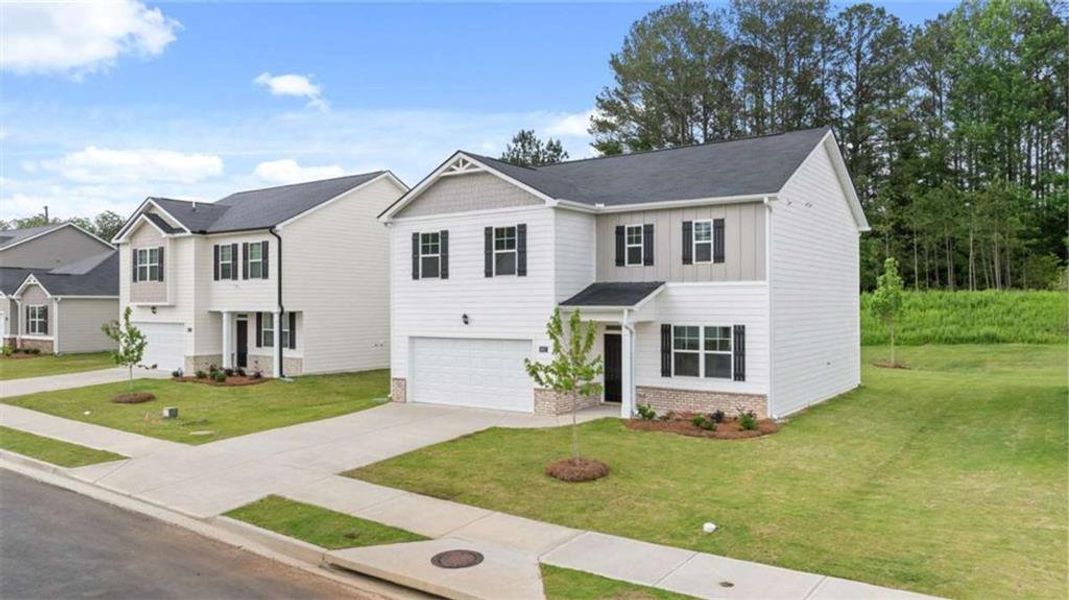 Front exterior of a new home in Poplar Preserve, Newnan, GA, highlighting curb appeal (Image 2). Front exterior of a new home in Poplar Preserve, Newnan, GA, highlighting curb appeal (Image 2).