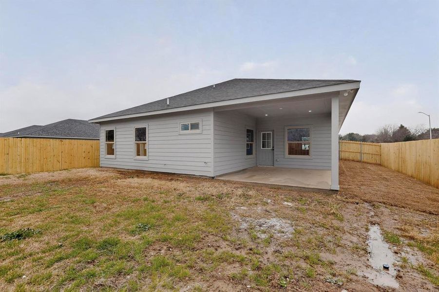 Back of property with a patio area, a fenced backyard, and a shingled roof