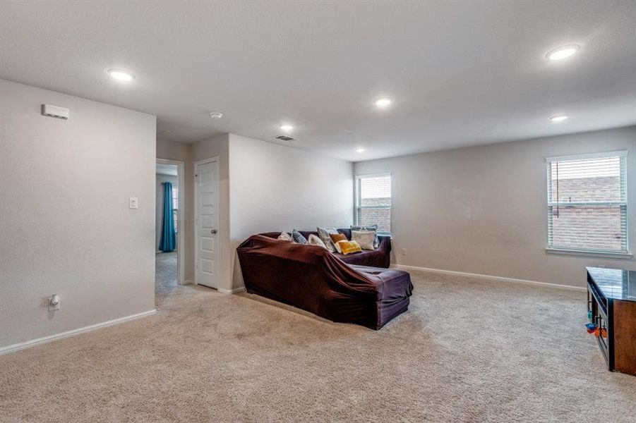 Living area featuring light colored carpet and recessed lighting