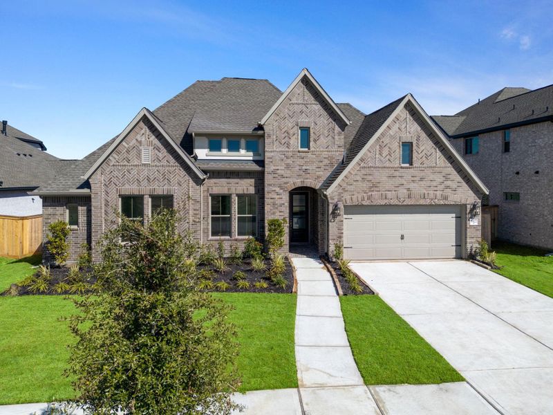 Front exterior of a new home in Valencia 70', Manvel, TX, highlighting curb appeal (Image 20).