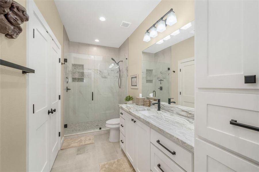 Bathroom with vanity, a shower stall, recessed lighting, and light tile patterned flooring