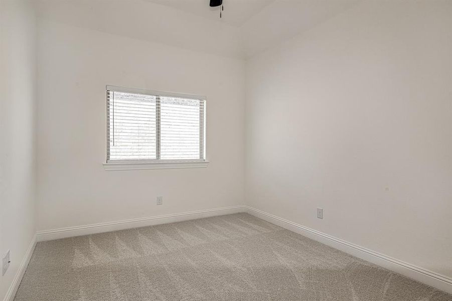 Carpeted empty room with ceiling fan