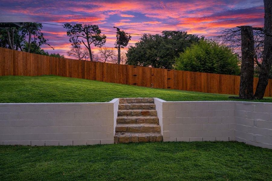 Yard at dusk with a fenced backyard